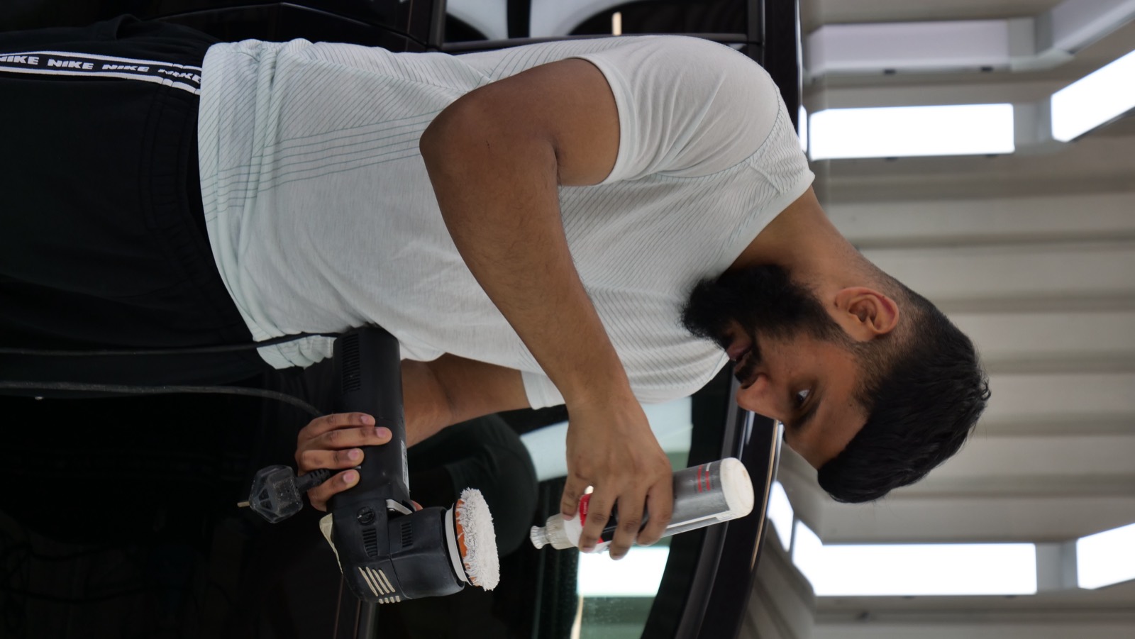 Student cutting and compounding paintwork by machine